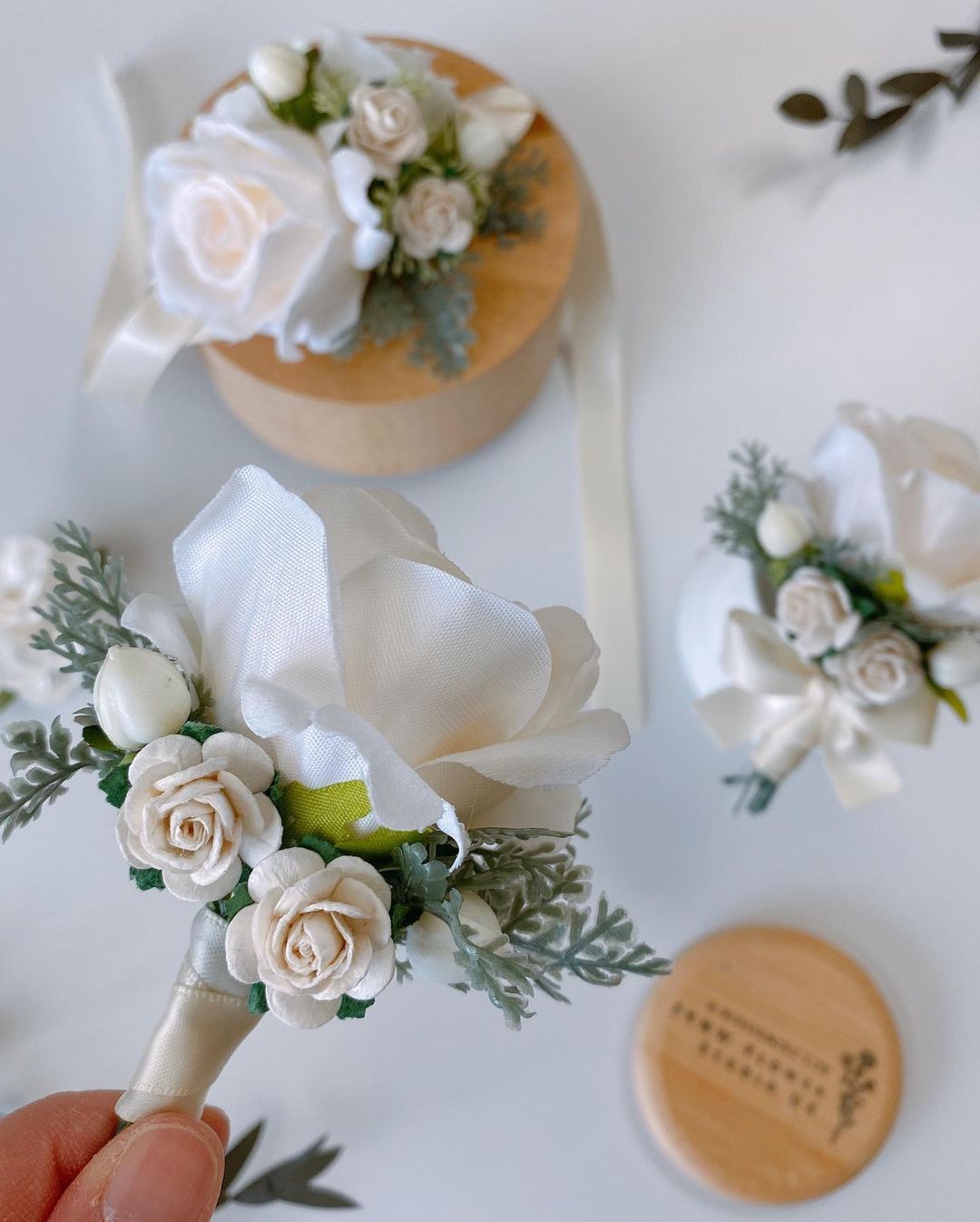 Eden Bridegroom Corsage Wedding Props -R220 is a corsage made of artificial flowers for weddings and other events. Corsage consists of white roses, violets and leaves and is adorned with a metal frame. Big enough for your guests to take pictures and keep. It&