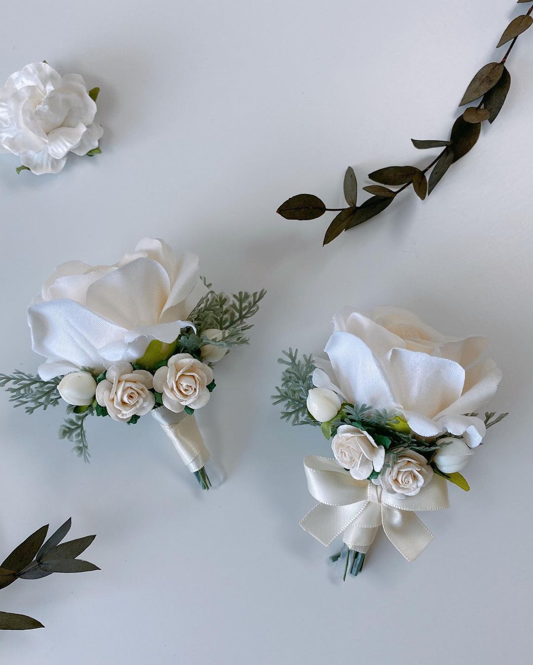 Eden Bridegroom Corsage Wedding Props -R220 is a corsage made of artificial flowers for weddings and other events. Corsage consists of white roses, violets and leaves and is adorned with a metal frame. Big enough for your guests to take pictures and keep. It&