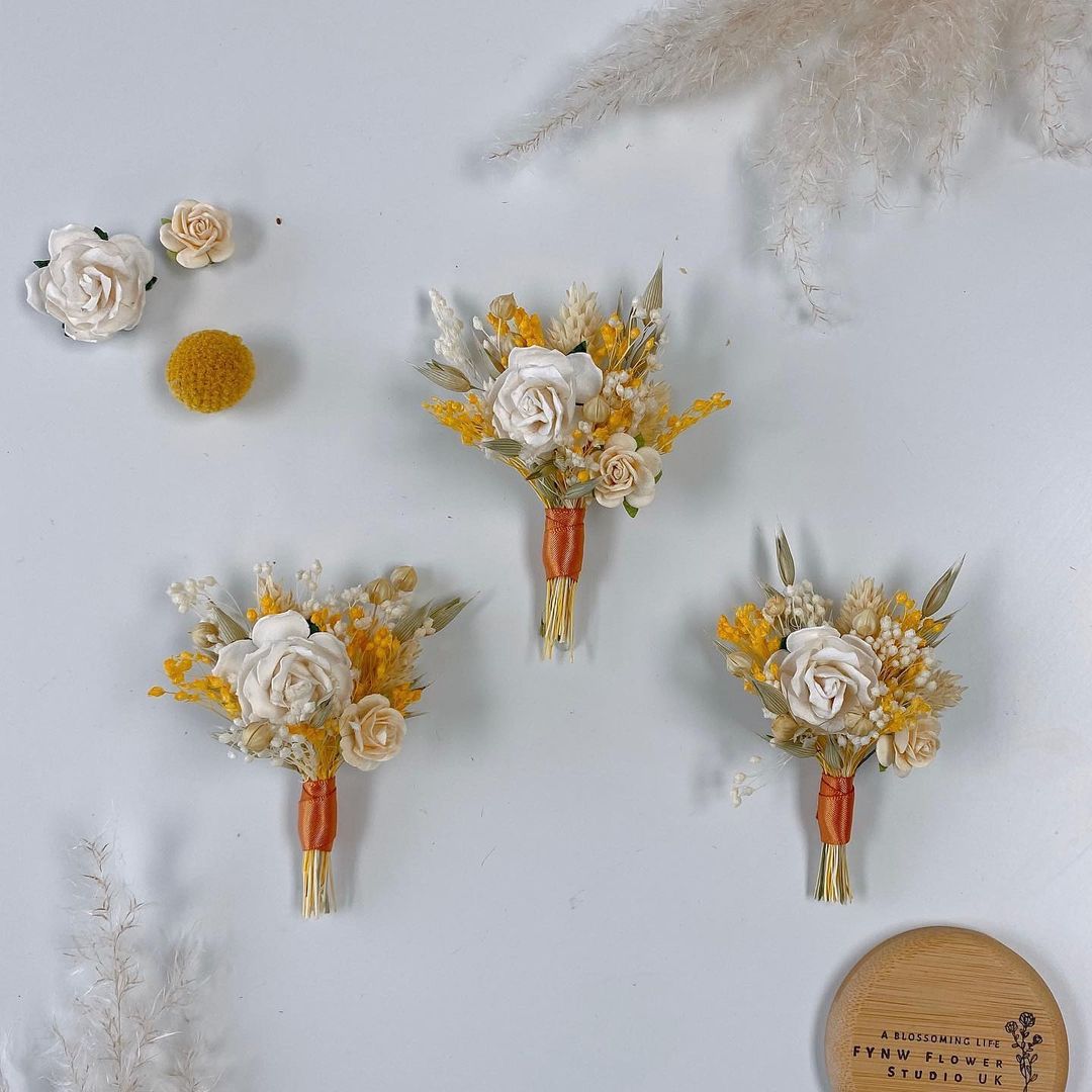Orlaith Wedding Props Groomsmen Corsage -R218 is a corsage made of faux white flowers for weddings and other events. Corsage consists of white roses, violets and leaves and is adorned with a metal frame. Big enough for your guests to take pictures and keep. It&