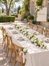 Galia welcome package with table runner, side-tied chair flowers and welcome sign in a French garden
