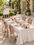 Gianna welcome package with table runner, side-tied chair flowers and welcome sign in a garden courtyard