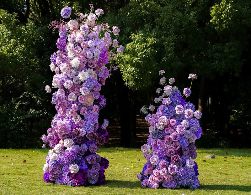 Two purple and lilac floral pillars standing on a lawn